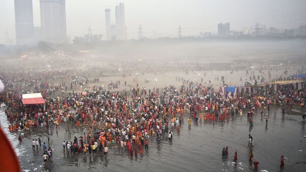 During Chhath Puja on Sunday, people gather in Delhi's Kalindi Kunj to witness worshipers offering prayers on the Yamuna's banks.